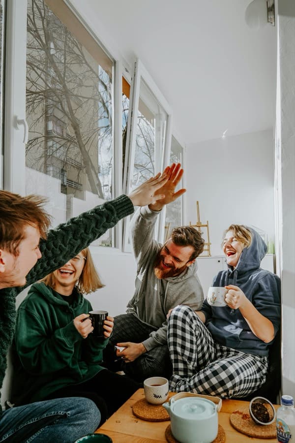 Friends high-fiving on a couch