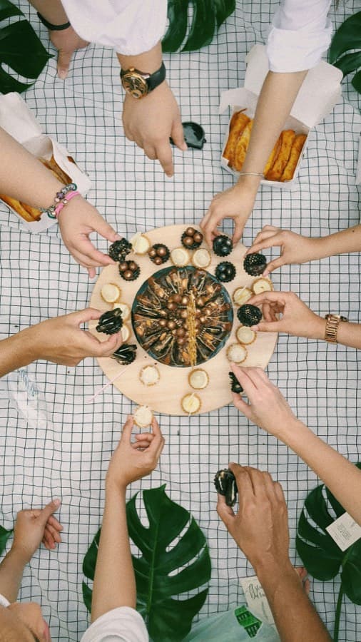 Hands reaching for a snack board